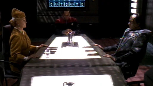 Kai Winn negotiates with Legate Turrel while Sisko mediates.