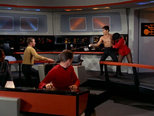 Sulu brandishing a fencing foil at Kirk on the bridge while Uhura resists his 'rescue'
