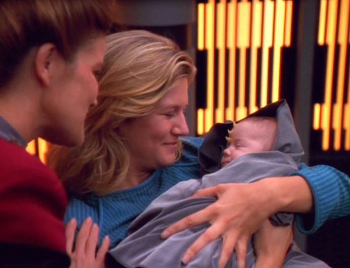 Ensign Wildman holds her baby.